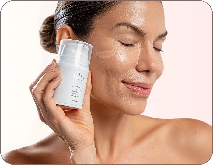 Smiling woman applying ILLU Hydro Gel Activator to her cheek, enhancing skin hydration and optimizing device performance.