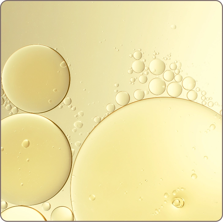 Macro image of golden serum bubbles illustrating Vitamin E’s antioxidant power for repairing and improving skin texture.