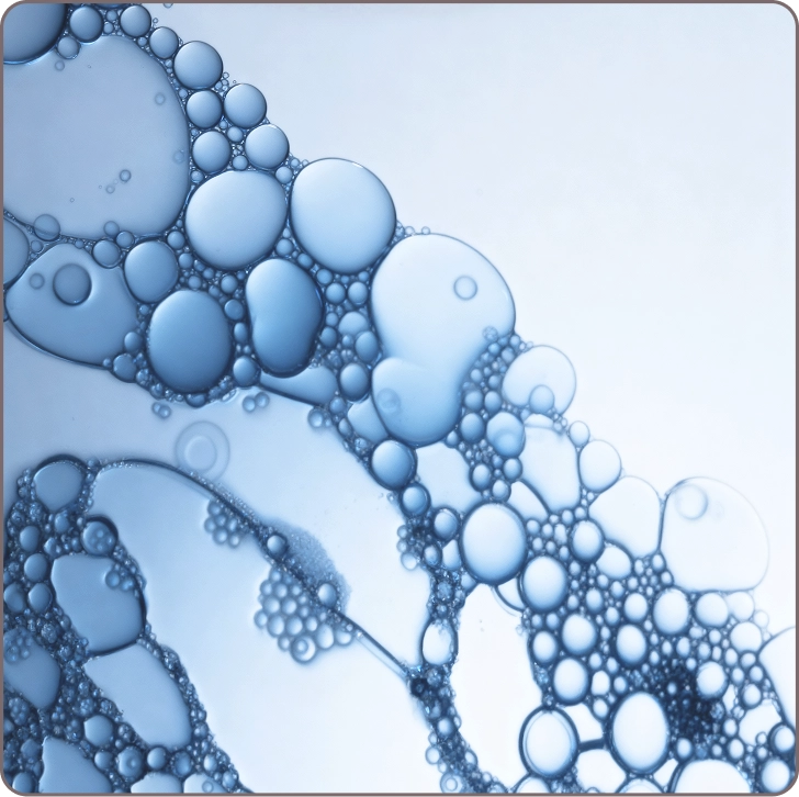Close-up of blue serum bubbles representing niacinamide’s role in reducing redness, balancing tone, and boosting elasticity.